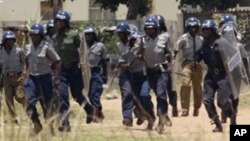 FILE: Police leave a scene after throwing teargas at a house in Chitungwiza, Zimbabwe, Sunday, Nov. 6, 2011. 