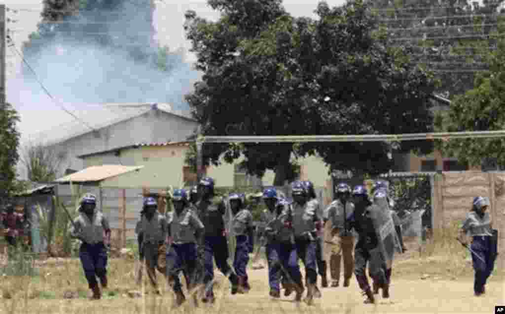 Police leavethe scene after throwing teargas at a house in Chitungwiza, Zimbabwe, Sunday, Nov. 6, 2011. The party of Zimbabwe's prime minister says 22 people were injured and property was destroyed after ruling party militant youths attacked hundreds of s