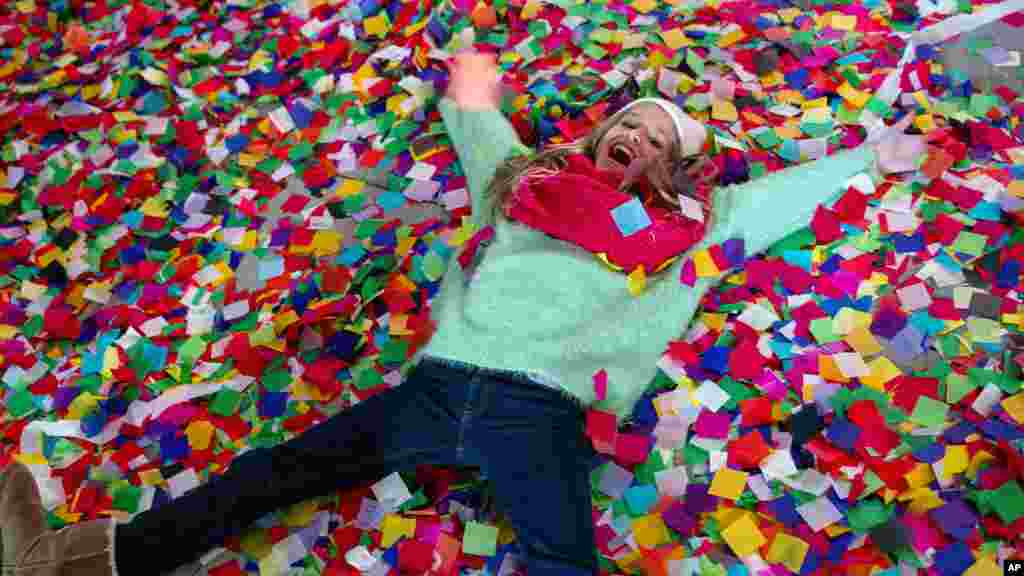Nicole Tacher, 11, lays in confetti on a hotel balcony as the new year is celebrated, Times Square, New York City, New York, Jan. 1, 2014.