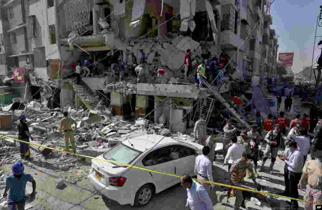 Pakistan&#39;s troops and rescue workers look for survivors in the rubble following the explosion, in Karachi.