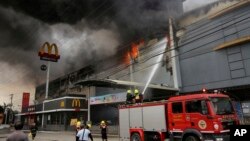 آگ بچھانے والے کارکن فلپائن کے شہر ڈاوئیو کے شاپنگ مال میں لگی آب بچھانے کی کوشش کر رہے ہیں۔ 23 دسمبر 2017