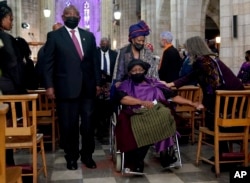 President Cyril Ramaphosa, left, leaves the church with widow Leah Tutu at the end of the funeral service for Anglican Archbishop Emeritus Desmond Tutu in St. George's Cathedral in Cape Town, South Africa, Jan. 1, 2022.