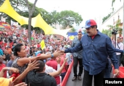 Venezuela's President Nicolas Maduro greets supporters during a rally in support of the Venezuelan government's housing programs at Miraflores Palace in Caracas, Venezuela, May 11, 2016.