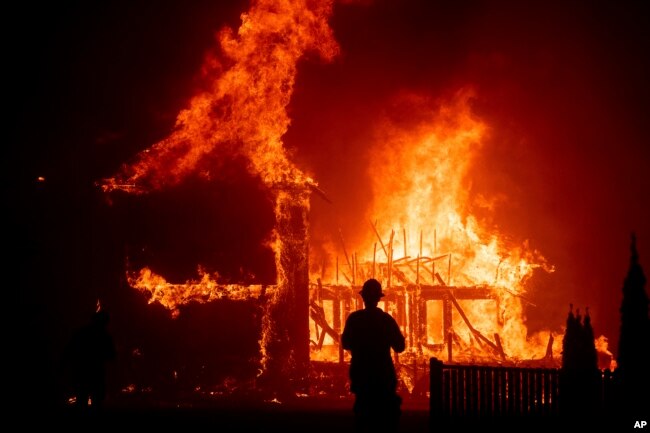 A home burns as the Camp Fire rages through Paradise, Calif., Nov. 8, 2018.