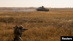 FILE - A Ukrainian soldier takes part in a drill at a training ground near the border with Russia-annexed Crimea, in Kherson region, Ukraine, in this handout picture released by the General Staff of the Armed Forces of Ukraine press service Nov. 17, 2021. 