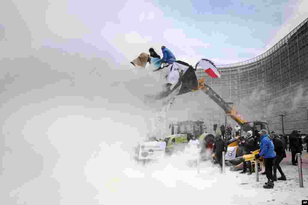 European dairy farmers spray the EU Council building with milk powder to protest the crisis in their sector, in Brussels, Belgium.