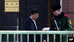 지난 2012년 중국 베이징 주재 북한대사관 입구에서 대사관 관계자가 경비를 서는 중국 공안원과 대화하고 있다. (자료사진)