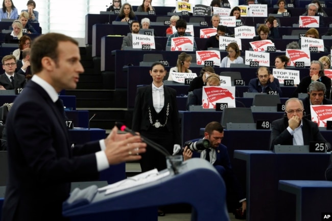 European lawmakers raise placards reading "Stop the War in Syria" in protest against airstrikes launched by the U.S., Britain and France in Syria last week.