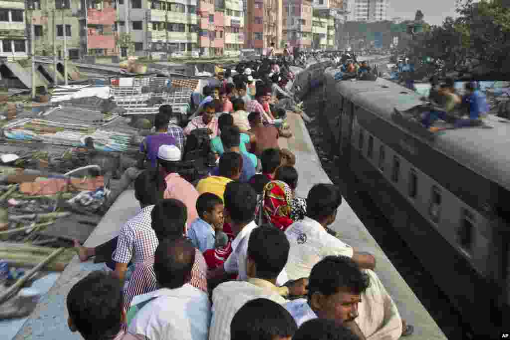 Bangladeshi Muslims travel on the roof of a crowded train as they head to their homes ahead of Eid al-Adha in Dhaka, Bangladesh. 