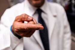 美国宾州匹兹堡大学一名科研人员展示刚刚研发出来的指尖大小的抗新冠病毒疫苗。（2020年4月2日）