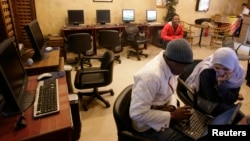 FILE - People sit in an internet cafe in Cairo, Feb. 3, 2008. 