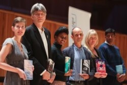 Booker Prize shortlisted fiction authors Patricia Lockwood, Richard Powers, Nadifa Mohamed, Damon Galgut, Maggie Shipstead and Anuk Arudpragasam pose with their books, during a photo-call in London, Britain, October 31, 2021.