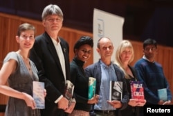 Booker Prize shortlisted fiction authors Patricia Lockwood, Richard Powers, Nadifa Mohamed, Damon Galgut, Maggie Shipstead and Anuk Arudpragasam pose with their books, during a photo-call in London, Britain, October 31, 2021.