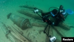 Divers are seen during the discovery of a centuries-old shipwreck, in Cascais, Portugal, Sept. 24, 2018