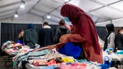 FILE - Afghan refugees pick out clothes at an Afghan refugee camp at Joint Base McGuire Dix Lakehurst, N.J., Sept. 27, 2021. The camp currently holds approximately 9,400 Afghan refugees and has a capacity to hold up to 13,000.