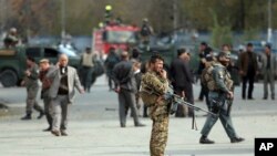 Petugas keamanan Afghanistan memeriksa lokasi ledakan bom dekat unjuk rasa ratusan warga Syiah di Kabul, 12 November 2018.