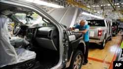 FILE- An assemblyman works on a Ford F-150 truck at the Ford Rouge plant in Dearborn, Michigan, Sept. 27, 2018.