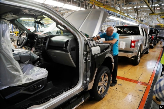 FILE- An assemblyman works on a Ford F-150 truck at the Ford Rouge plant in Dearborn, Mich., Sept. 27, 2018.