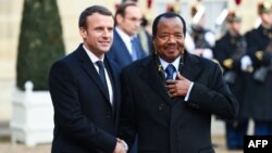 Le président français Emmanuel Macron, à gauche, salue son homologue camerounais Paul Biya à l'Elysée à Paris, le 12 décembre 2017.