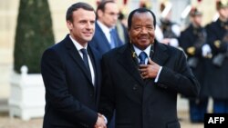 Le président français Emmanuel Macron, à gauche, salue son homologue camerounais Paul Biya à son arrivée à l'Elysée à Paris, le 12 décembre 2017.