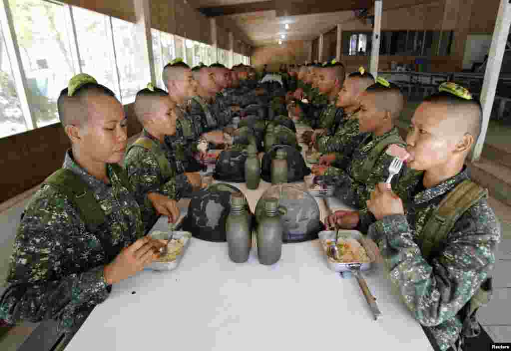 Marinir-marinir perempuan yang baru direkrut menyantap makan siang dengan tentara lainnya di sebuah markas marinir di kota Ternate, Cavite city, sebelah selatan Manila, Filipina.