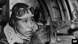 File photo shows Sgt. Gilbert Eagle Feather, Lakota from Rosebud, S.D., at the waist gun of his B-17 Flying Fortress, Dec. 24, 1943. 