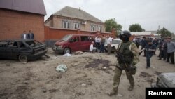 Investigators work at the site of a suicide bomb attack in the Malgobek district in the north of Ingushetia, August 19, 2012.