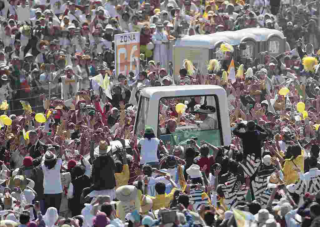 Una multitud de peregrinos saludó el paso del papa Benedicto XVI en el papamóvil. (AP)