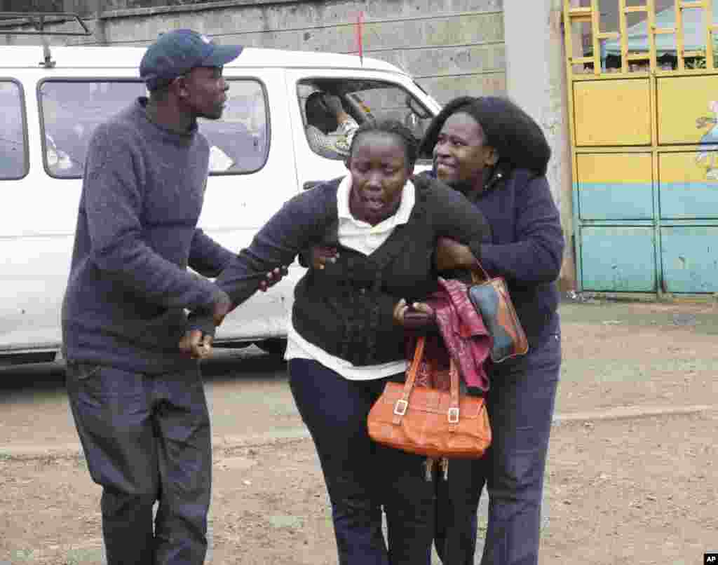 Para kerabat membantu seorang perempuan di kamar mayat Nairobi setelah ia mengidentifikasi jenazah seorang korban penembakan di pusat perbelanjaan (22/9). (AP/Khalil Senosi)