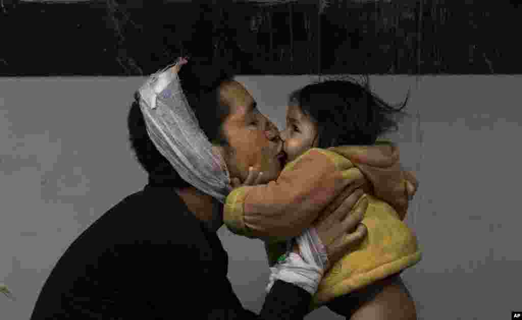 Earthquake injured Nepalese man Suresh Parihar plays with his daughter Sandhya at a hospital, in Kathmandu, Nepal, April 26, 2015.