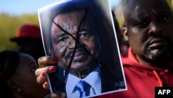 FILE - People protest Cameroon's President Paul Biya on Pennsylvania Avenue near the White House, Oct. 22, 2018 in Washington. In Cameroon, Security forces have been cracking down on street rallies protesting the October 7 re-election of President Paul Biya. 