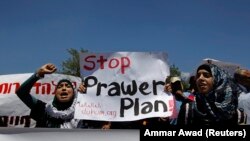 Bedouins hold signs as they take part in a protest against a plan to formally recognise Bedouin communities in the Negev desert, outside the Knesset, the Israeli parliament, in Jerusalem May 27, 2013. 