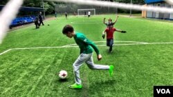 Kids play a pickup game of football in a central Moscow park. Russia hosts World Cup 2018 amid concerns its team may fair poorly. (C.Maynes for VOA)