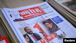 FILE - Ethiopia’s Prime Minister Abiy Ahmed and leader of the Tigray People's Liberation Front (TPLF) party Debretsion Gebremichael are pictured on the Maleda Local News papers, in Addis Ababa, Nov. 3, 2021.
