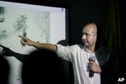 Ernesto Montenegro, director of the Colombian Institute of Anthropology and History of Colombia, talks to reporters while he shows a picture of remains of the galleon San Jose in Cartagena, Colombia, Dec.5, 2015.