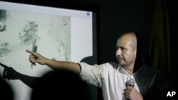 Ernesto Montenegro is director of the Colombian Institute of Anthropology and History of Colombia. Here, he talks to reporters while he shows a picture of remains of the galleon San Jose in Cartagena, Colombia, Dec.5, 2015.