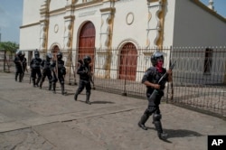   The heavily armed Nicaraguan police takes position before the arrival of President Daniel Ortega, in Masaya, Nicaragua, on Friday, 13. July 2018. 