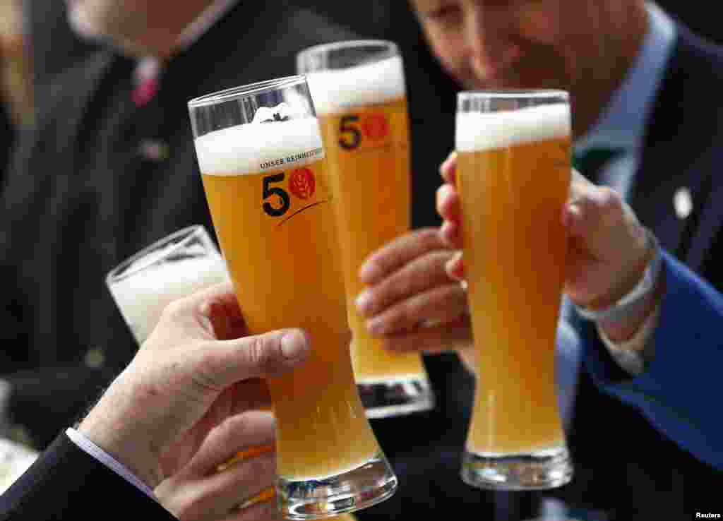 People hold beer glasses as they attend the 500th anniversary ceremony of the German Beer Purity Law (Reinheitsgebot) in Ingolstadt, Germany.