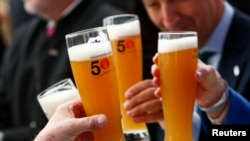 Des Allemands tiennent des bières pour le 500e anniversaire de la bière à Ingolstadt, Allemagne, le 22 avril 2016. 