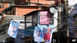 Carteles de candidatos del partido en el gobierno a la gobernación de Miranda, Héctor Rodríguez, a la derecha, y del aspirante a la alcaldía de Sucre, José Vicente Rangel, colgados en una calle en Caracas, el 19 de noviembre de 2021.