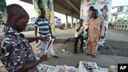 An Unidentified man reads a newspaper with the headline 'National Shame' after the election was postponed Saturday by Election Commission Chairman Attahiru Jega, Lagos, Nigeria, April 3, 2011