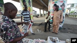 An unidentified man reads a newspaper with the headline 'National Shame' after the election was postponed Saturday by Election Commission Chairman Attahiru Jega, Lagos, Nigeria, April 3, 2011