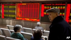 Investors gather near a display board showing the plunge in the Shanghai Composite Index at a brokerage in Beijing, China, Thursday, Jan. 7, 2016.