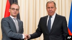 Russian Foreign Minister Sergey Lavrov, right, shakes hands with German Foreign Minister Heiko Maas after their joint news conference following talks in Moscow, Russia, May 10, 2018.