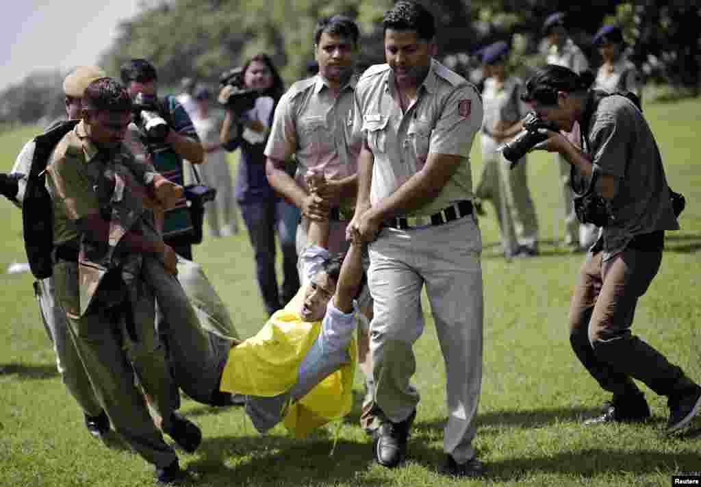 Police forcibly control an exiled Tibetan man during a protest against the visit of China's President Xi Jinping near the Chinese embassy, in New Delhi, Sept. 17, 2014. 