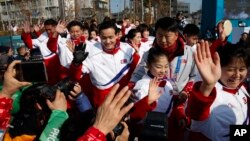 평창동계올림픽에 참가한 북한 선수단이 지난 8일 선수촌 입촌 환영행사에서 취재진과 시민들에게 손을 흔들고 있다.