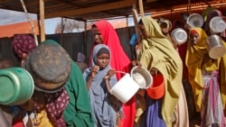 FILE - Women who fled drought queue to receive food at a camp for internally displaced persons, in the Daynile neighborhood on the outskirts of the capital Mogadishu, Somalia, May 18, 2019.