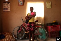 Virginia Mavhunga, a 13-year-old teenage mother, hold her child , Saturday, Dec. 11, 2021.(AP Photo/Tsvangirayi Mukwazhi)