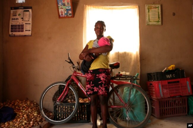 Virginia Mavhunga, a 13-year-old teenage mother, hold her child , Saturday, Dec. 11, 2021.(AP Photo/Tsvangirayi Mukwazhi)