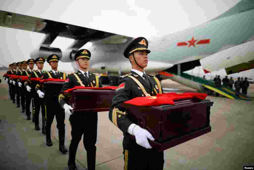 Soldiers carry caskets containing the remains of Chinese soldiers during the handing over ceremony at the Incheon International Airport in Incheon, South Korea.